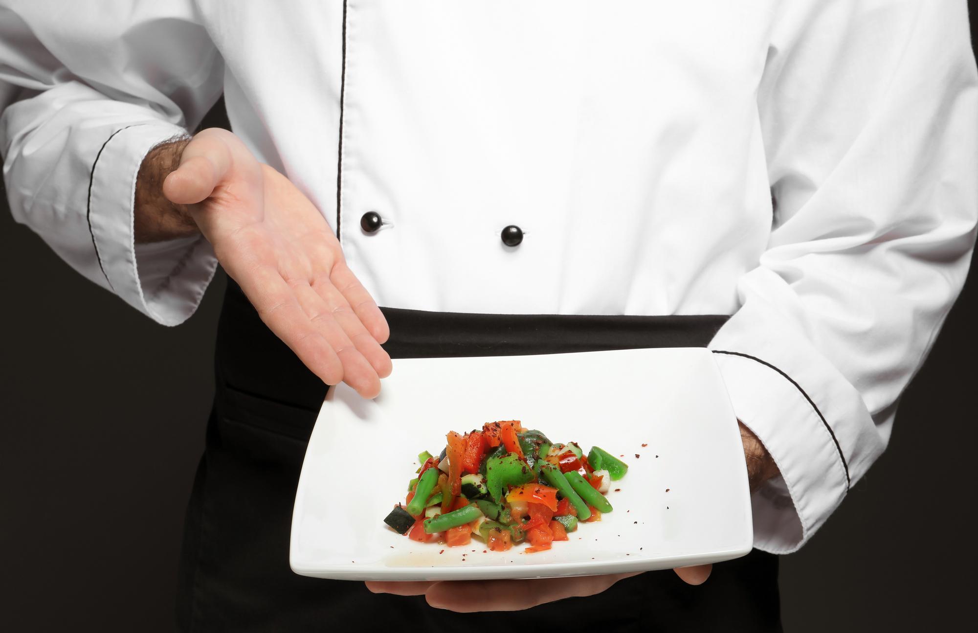 Chef che prepara una portata elegante in cucina moderna